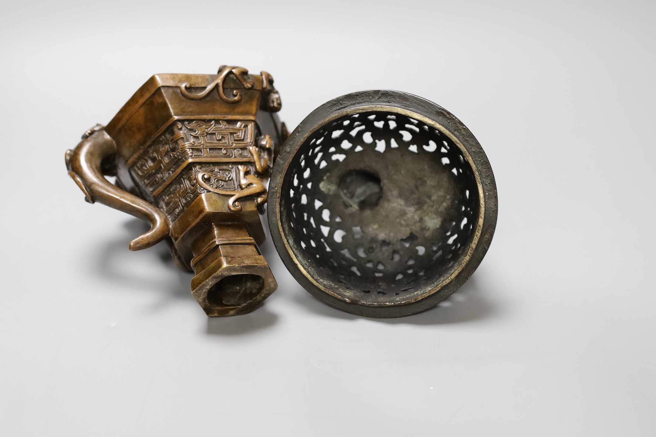 A Chinese bronze handled libation cup, together and a bronze cover with pierced decoration and seated dog, tallest 12cm